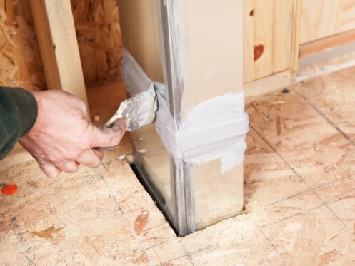 A man sealing an air duct in a Canton, OH home